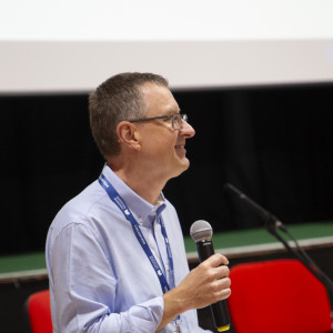 Alan Hurcombe, Festival Chair, holds a microphone